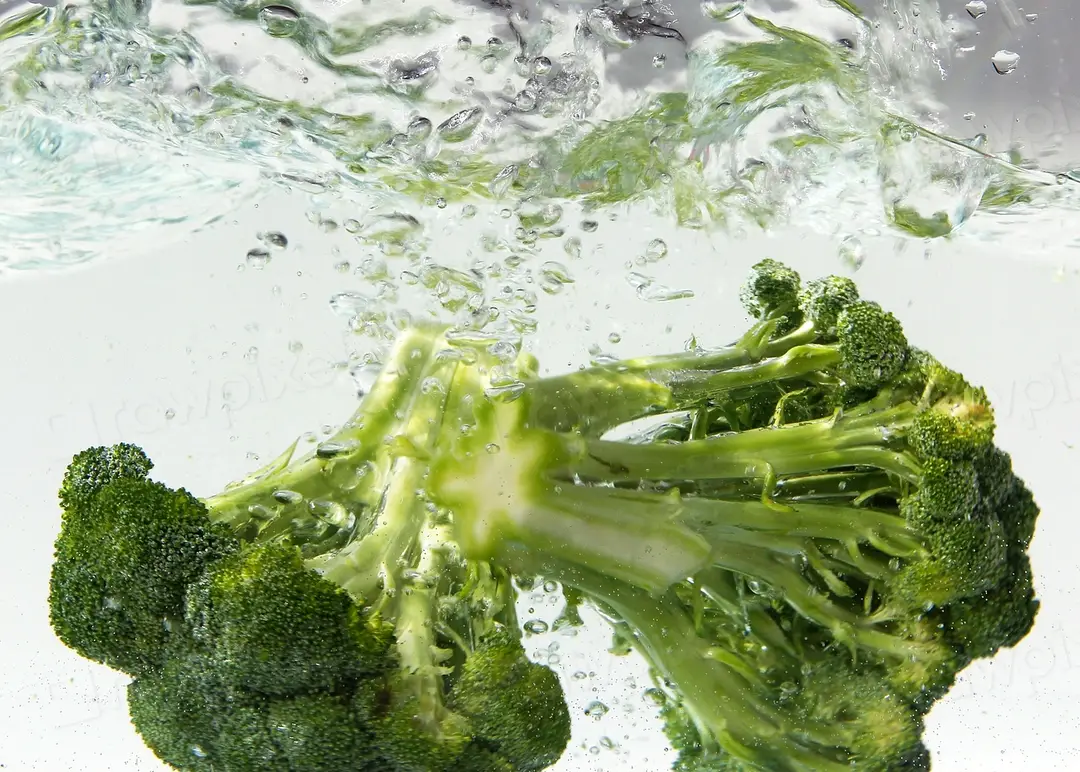 Broccoli being rinsed under water